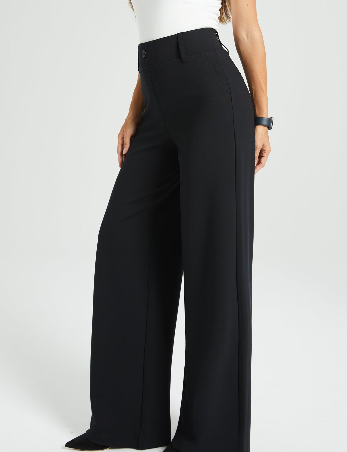 Black wide-leg pants worn by a woman on a white background