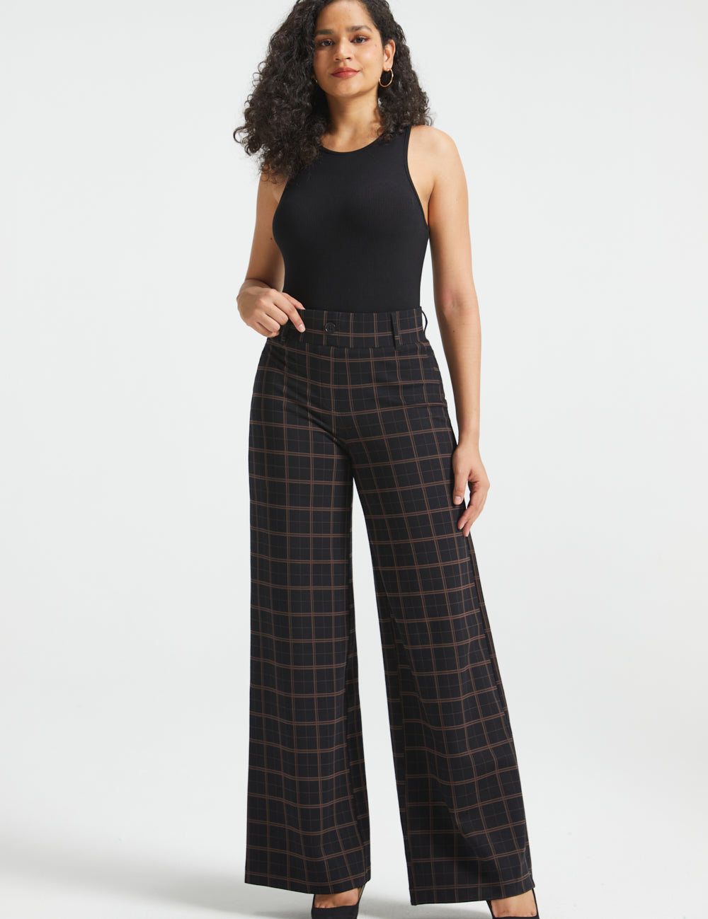 Woman wearing Black Brown Plaid high-waisted wide-leg Dress Pant Yoga Pants with a black sleeveless top and black heels, full front view