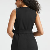 Back view of woman wearing black tailored ponte vest showing the belted waist, princess seaming and back vent