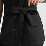 Close-up of black ponte vest showing removable self-tie belt and button-front closure