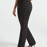 Woman wearing Black Brown Plaid straight-leg Dress Pant Yoga Pants with a black sleeveless top and black heels, side view