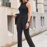 Woman wearing Black Brown Plaid straight-leg Dress Pant Yoga Pants with a black sleeveless top and black heels outdoors