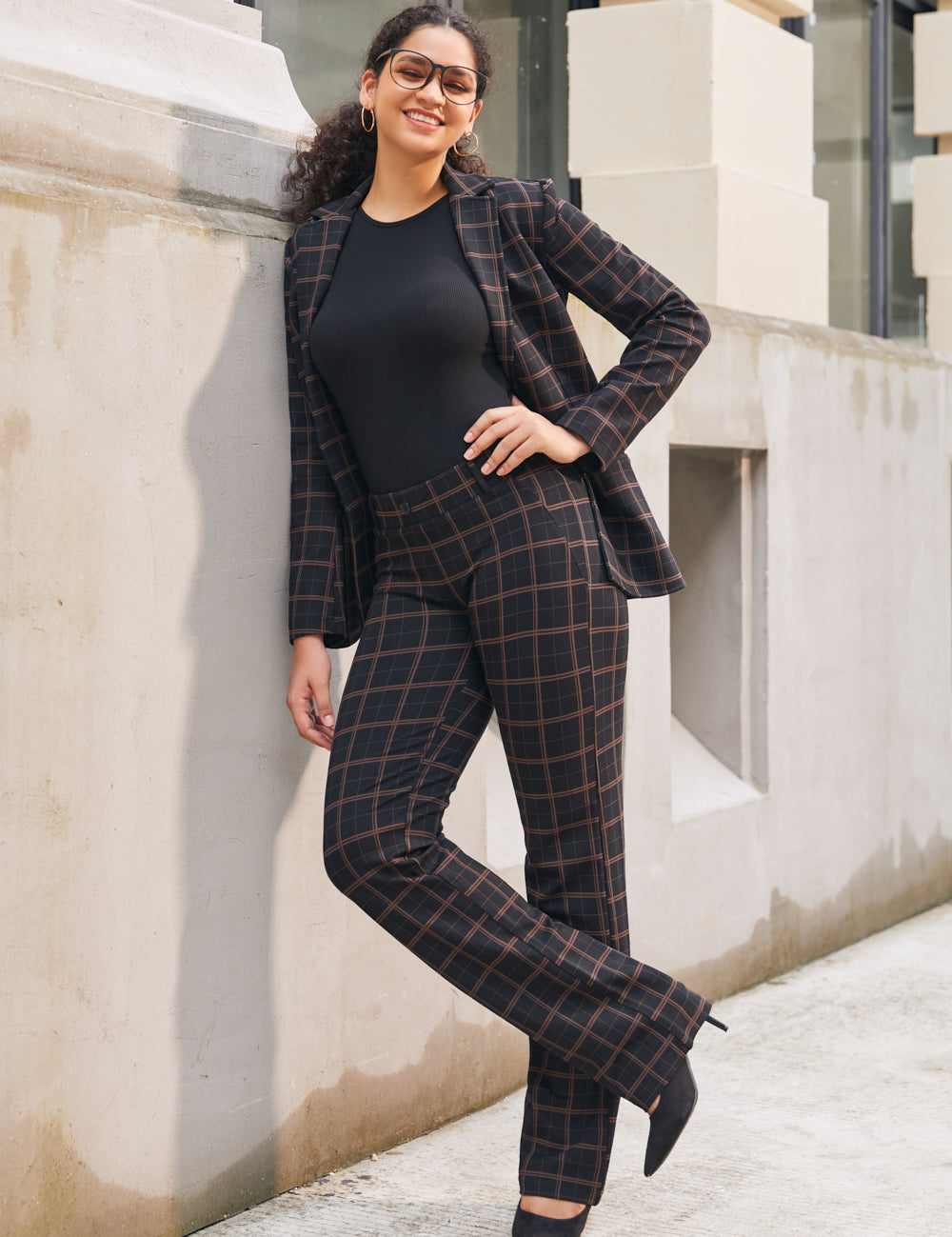 Woman wearing matching Black Brown Plaid straight-leg pants and Classic Blazer with a black top and heels outdoors