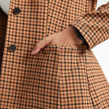 Close-up of hand in the functional welt pocket of the Camel Mini Houndstooth Classic Blazer