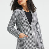 Woman wearing the black and ivory cat print Classic Blazer buttoned with one hand in the functional front pocket