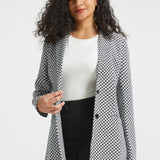 Woman wearing the Black Ivory Catstooth Classic Blazer open over a white top with black wide-leg pants