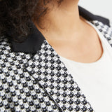 Close-up of the black and ivory cat print blazer showing the contrast black collar, notched lapel and tiny cat face pattern