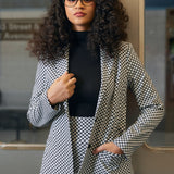Woman wearing the black and ivory cat print Classic Blazer over a black turtleneck with matching skirt in an office setting
