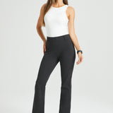 Woman wearing a white sleeveless top and grey work pants on a white background